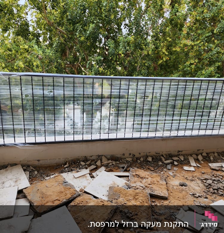 מעקה מתכת עם ניילון נצמד על רקע עצים